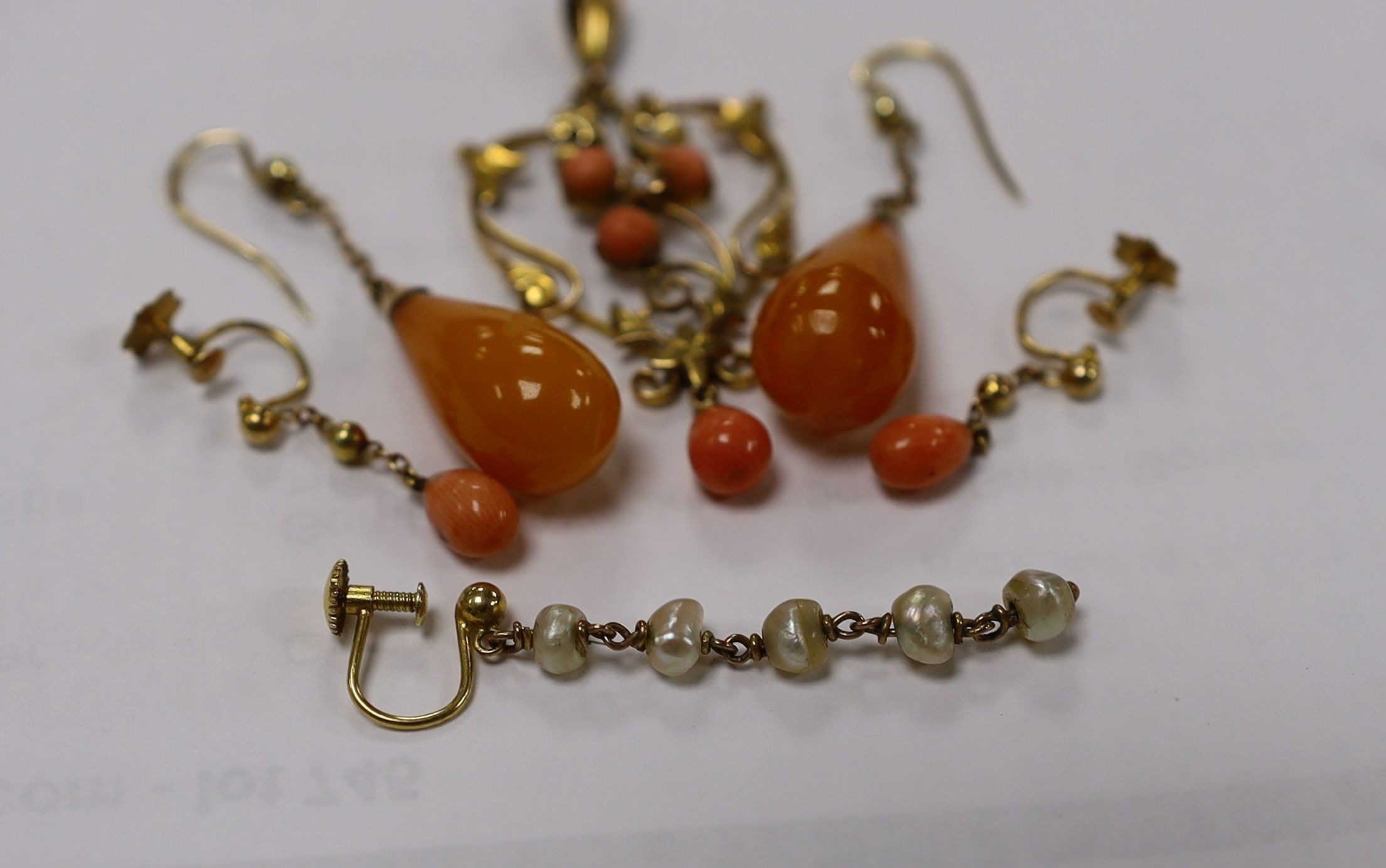 A gold and coral mounted pendant and coral earrings and a pair of amber and gold earrings